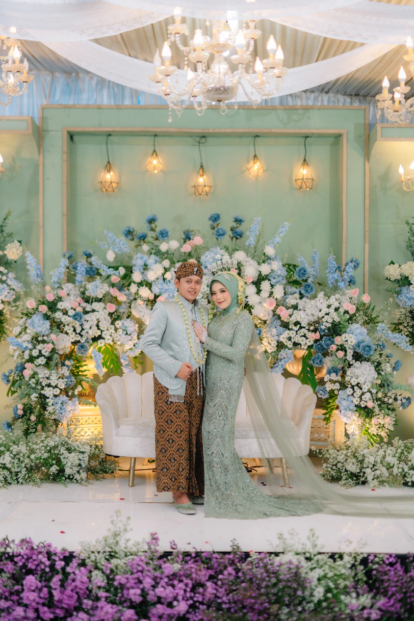 a couple posing for a picture in front of a floral backdrop
