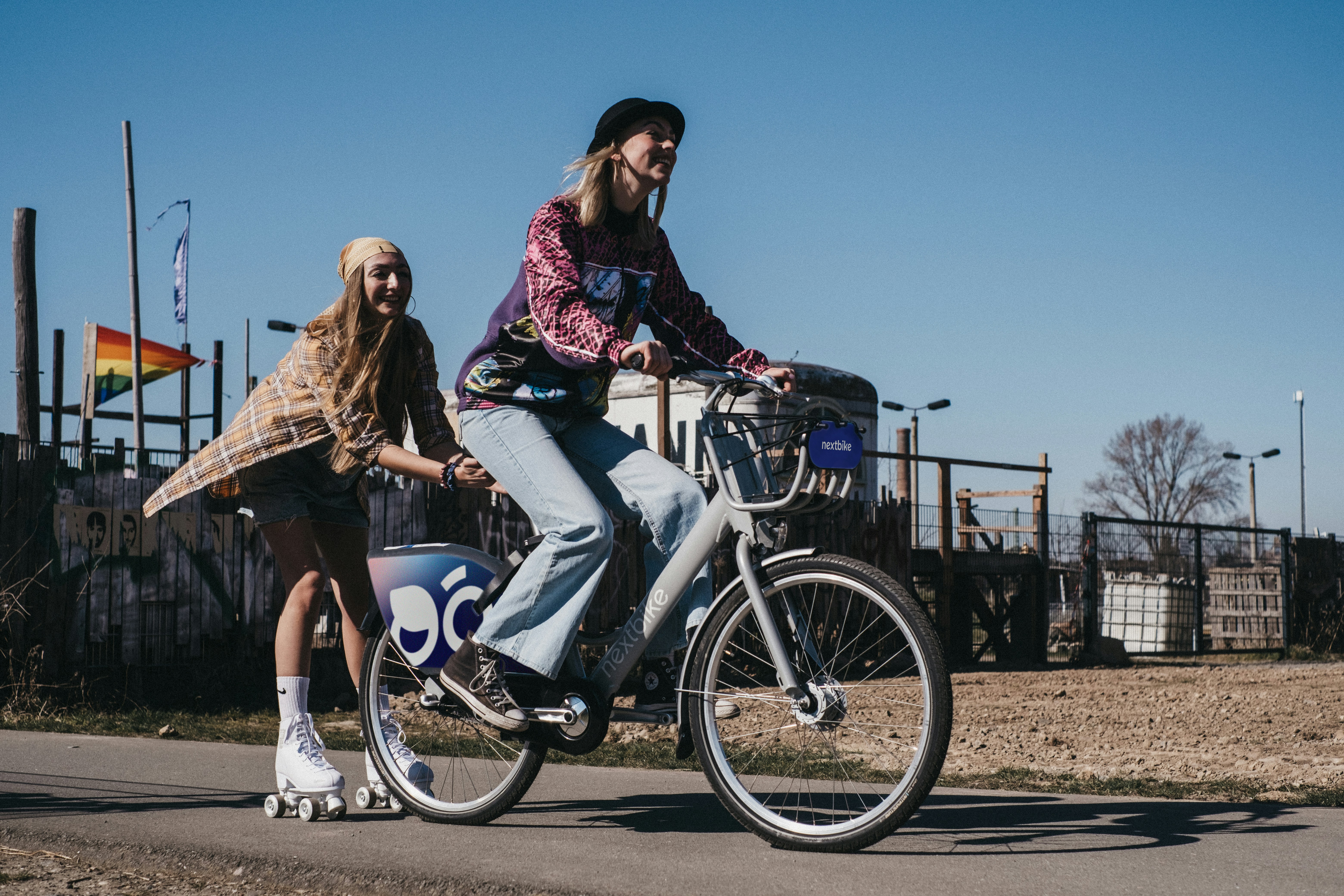 a woman riding a bike next to a girl on a skateboard