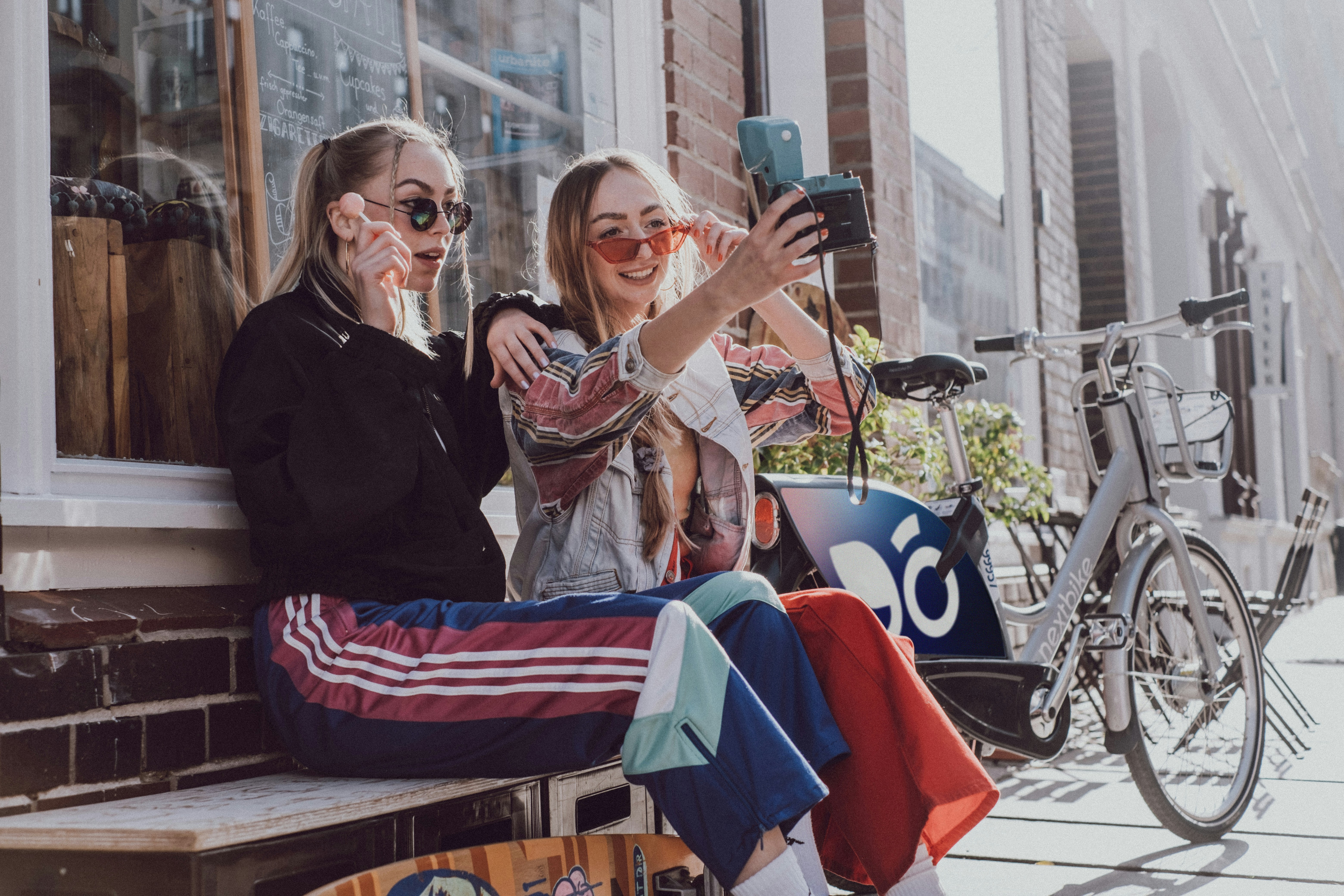 two women taking a selfie in front of a store