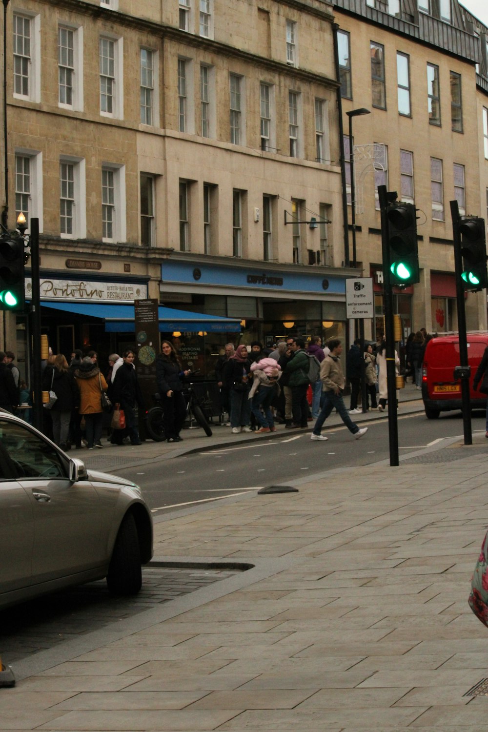 a crowd of people walking down a street next to tall buildings