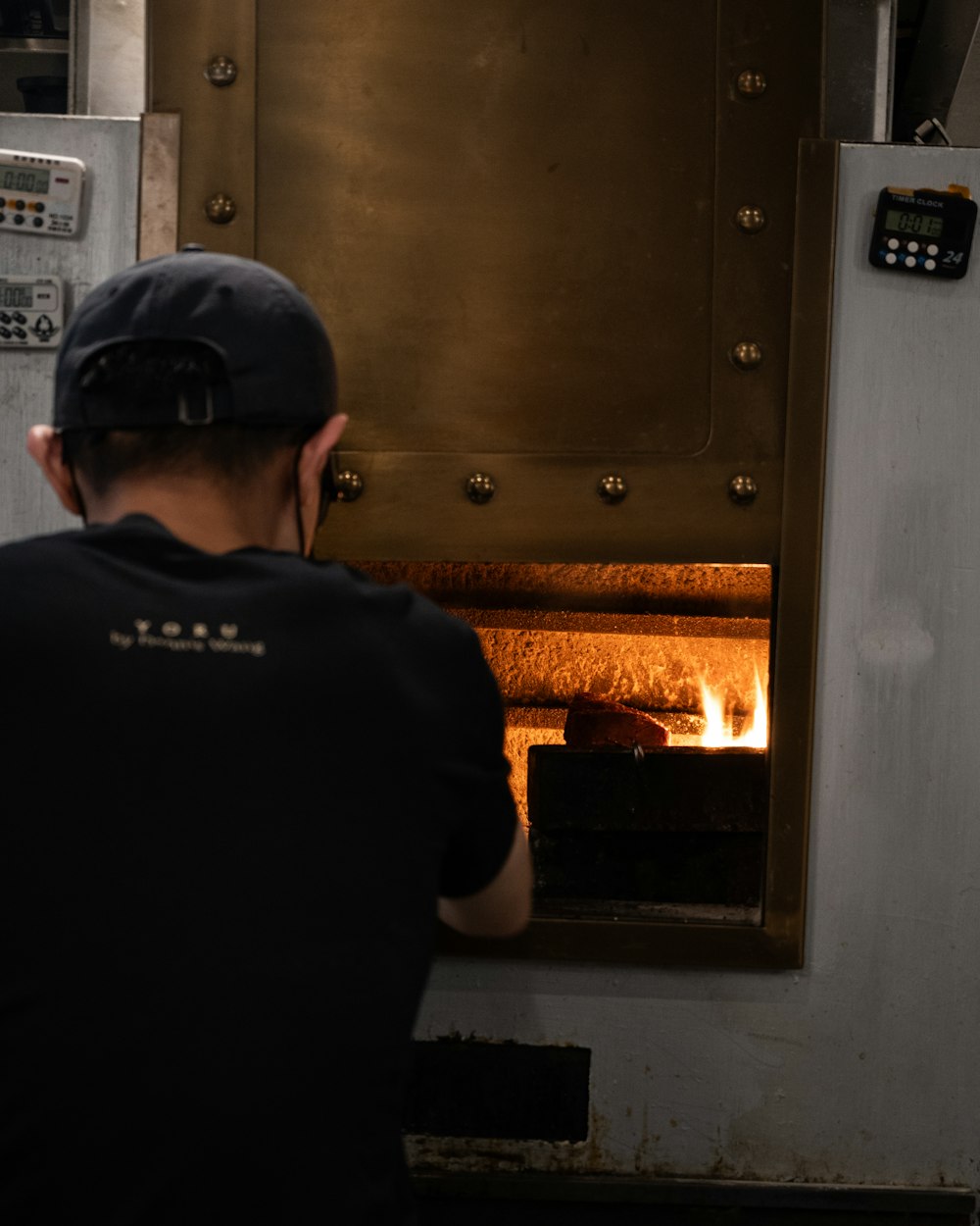 a man standing in front of a metal oven