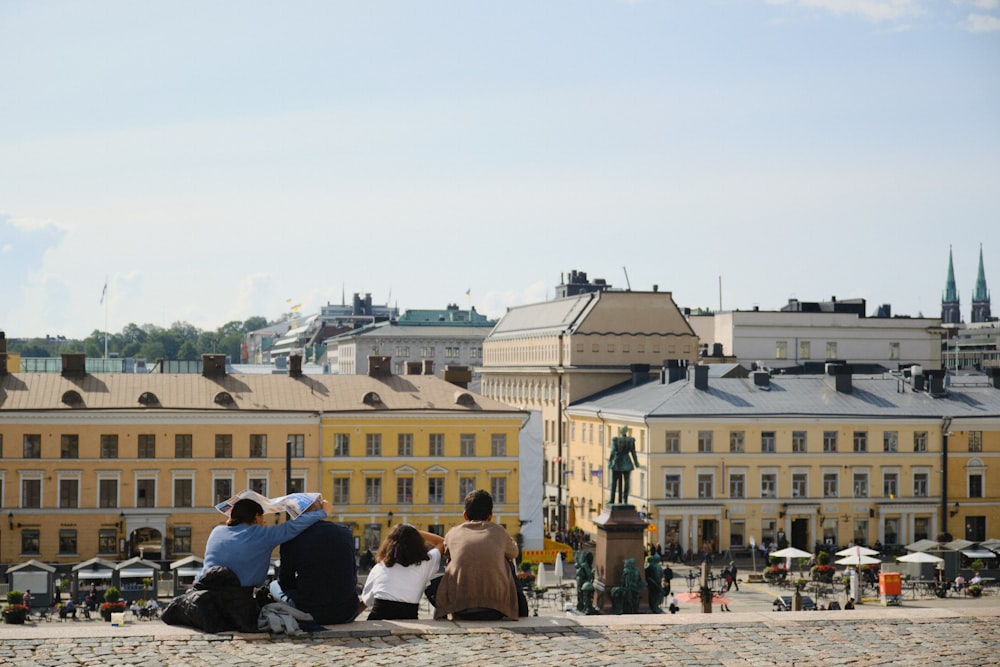 a group of people sitting on top of a stone walkway