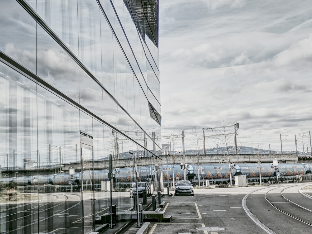 a train traveling past a tall building next to a street