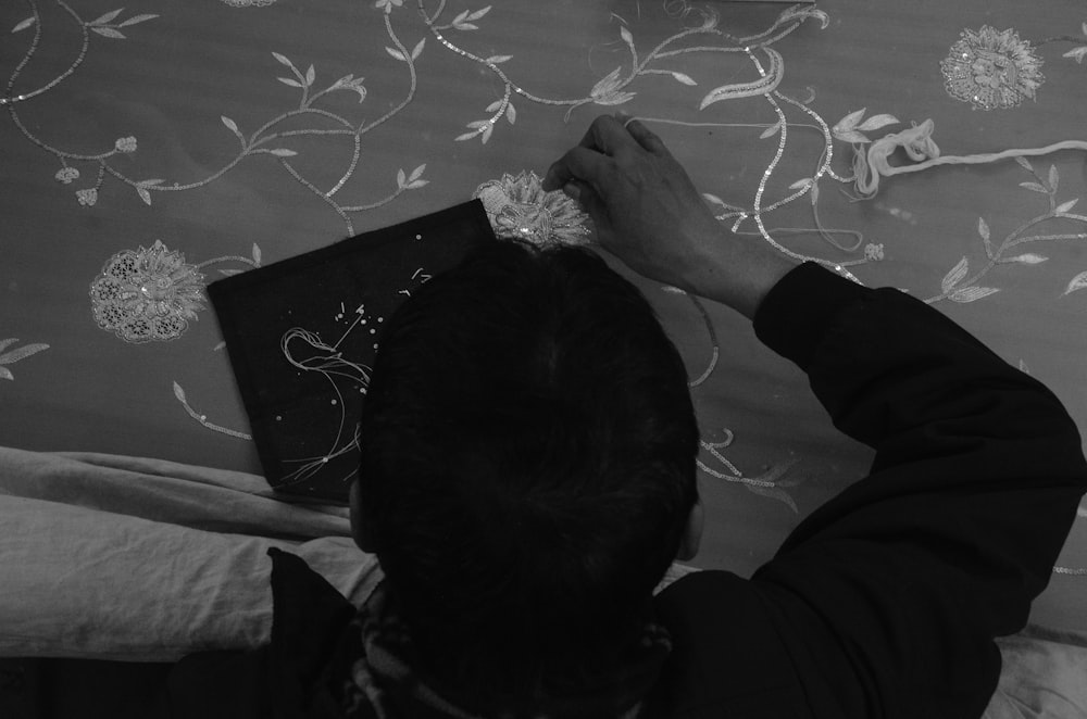a black and white photo of a person working on a wall