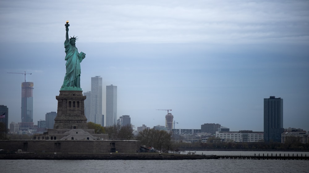 the statue of liberty stands in front of the city skyline