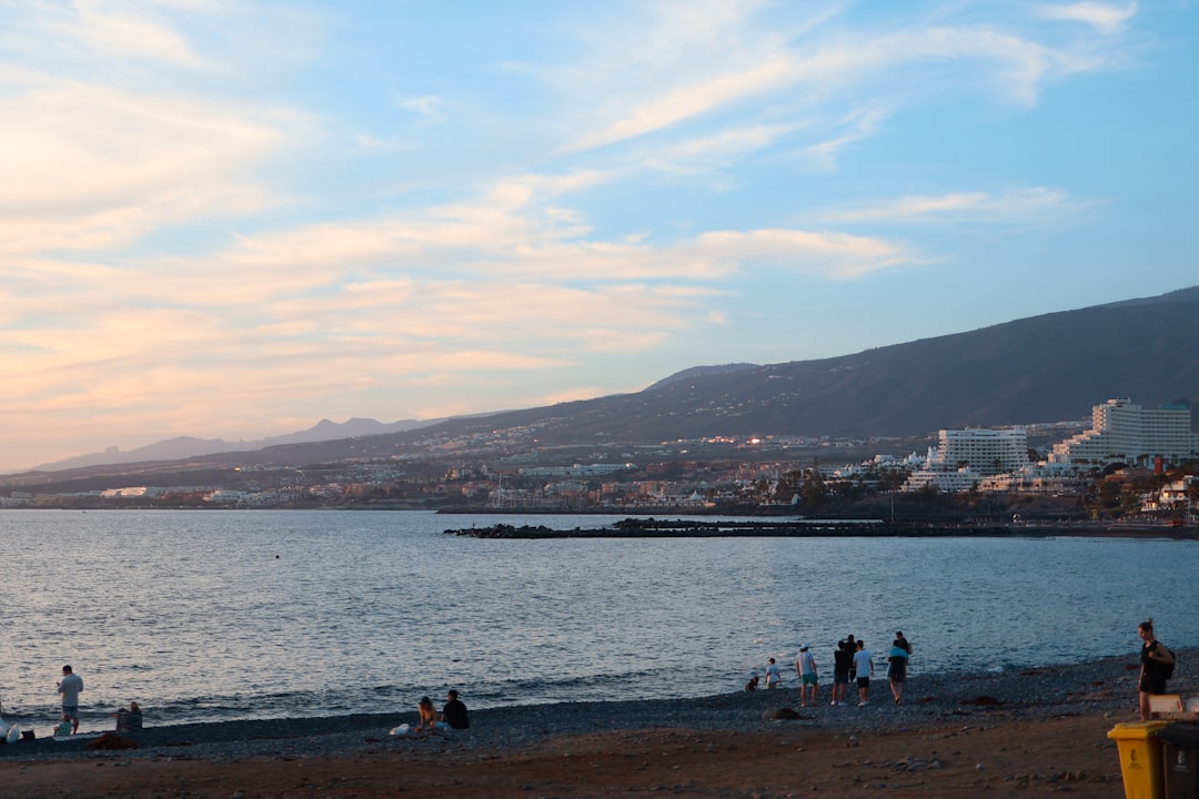 a group of people standing on top of a beach,