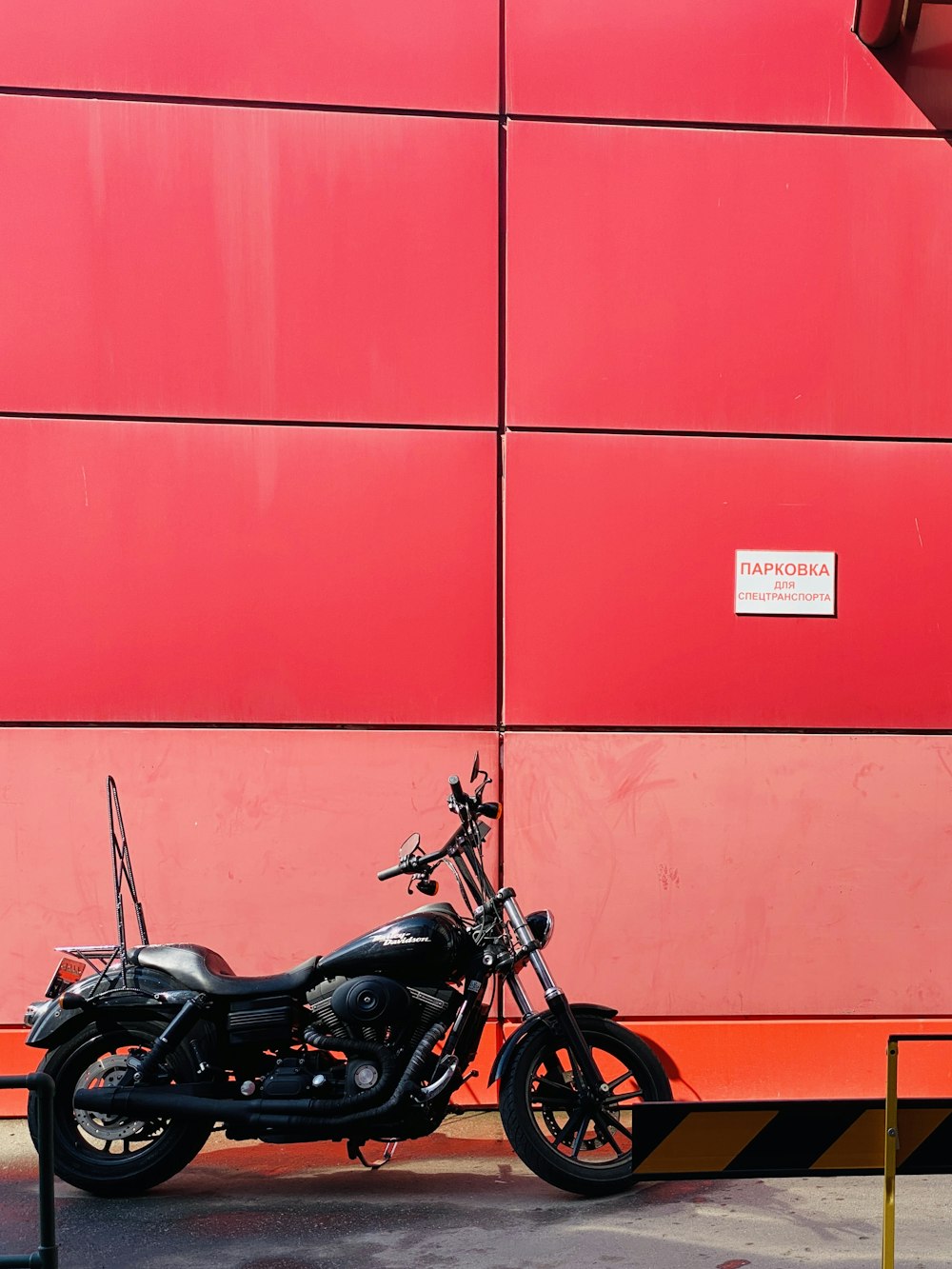 a motorcycle parked in front of a red wall