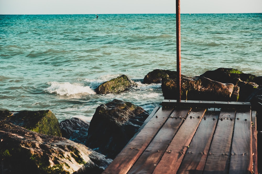 a wooden dock sitting on top of a rocky beach
