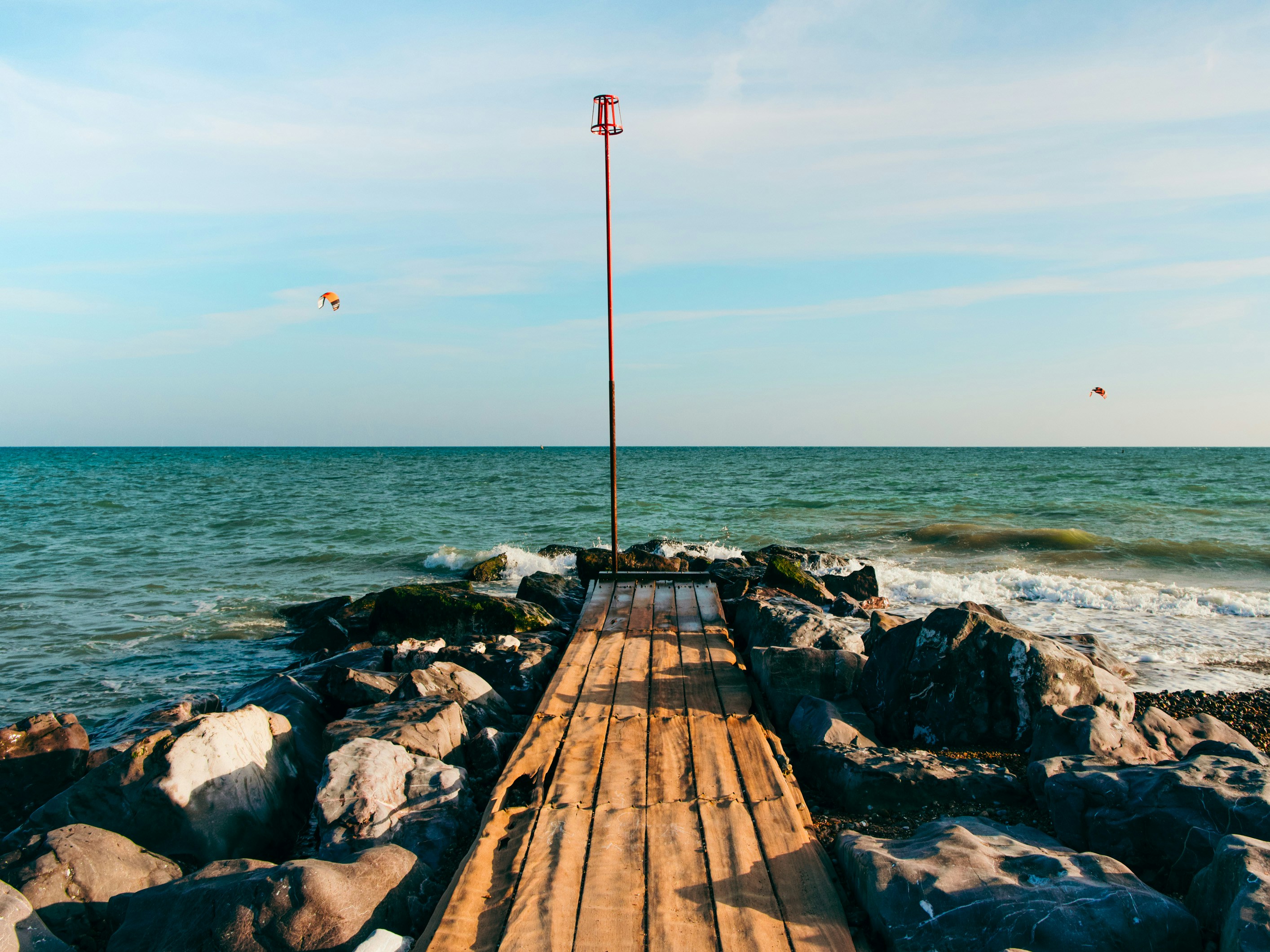 a wooden dock sitting on top of a rocky beach