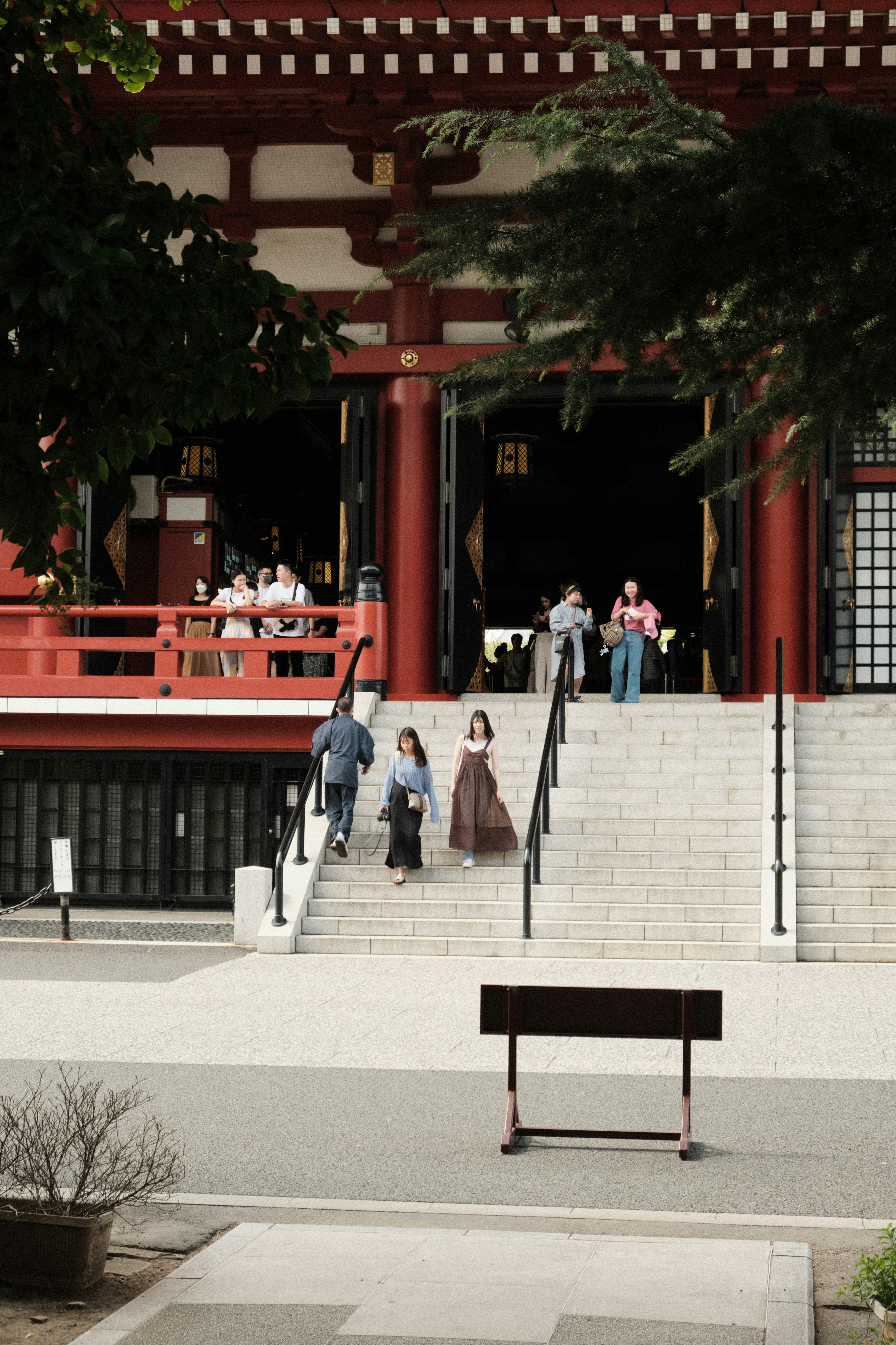 A woman sitting on a bench in front of a building photo – Free Travel ...