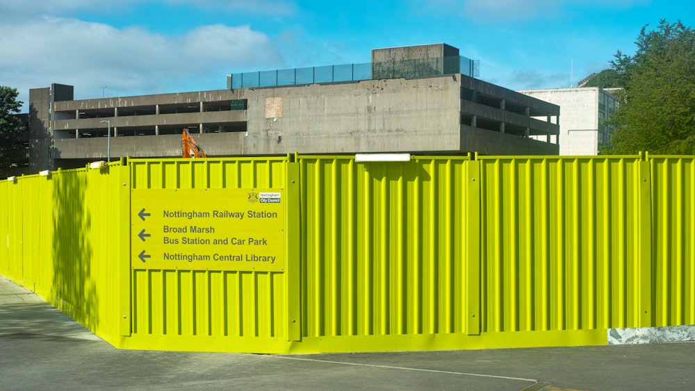 a yellow fence with a building in the background