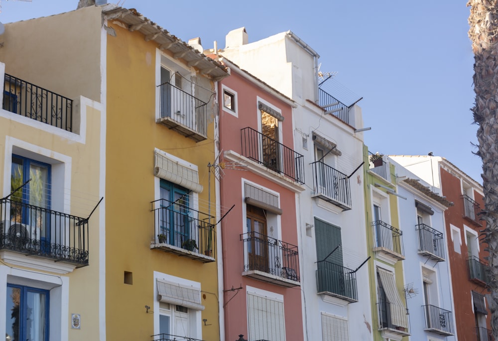 a row of multicolored buildings with balconies and balconies