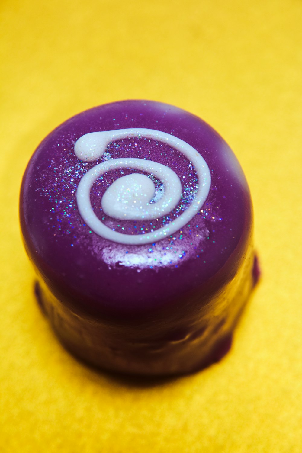 a close up of a purple object on a yellow surface