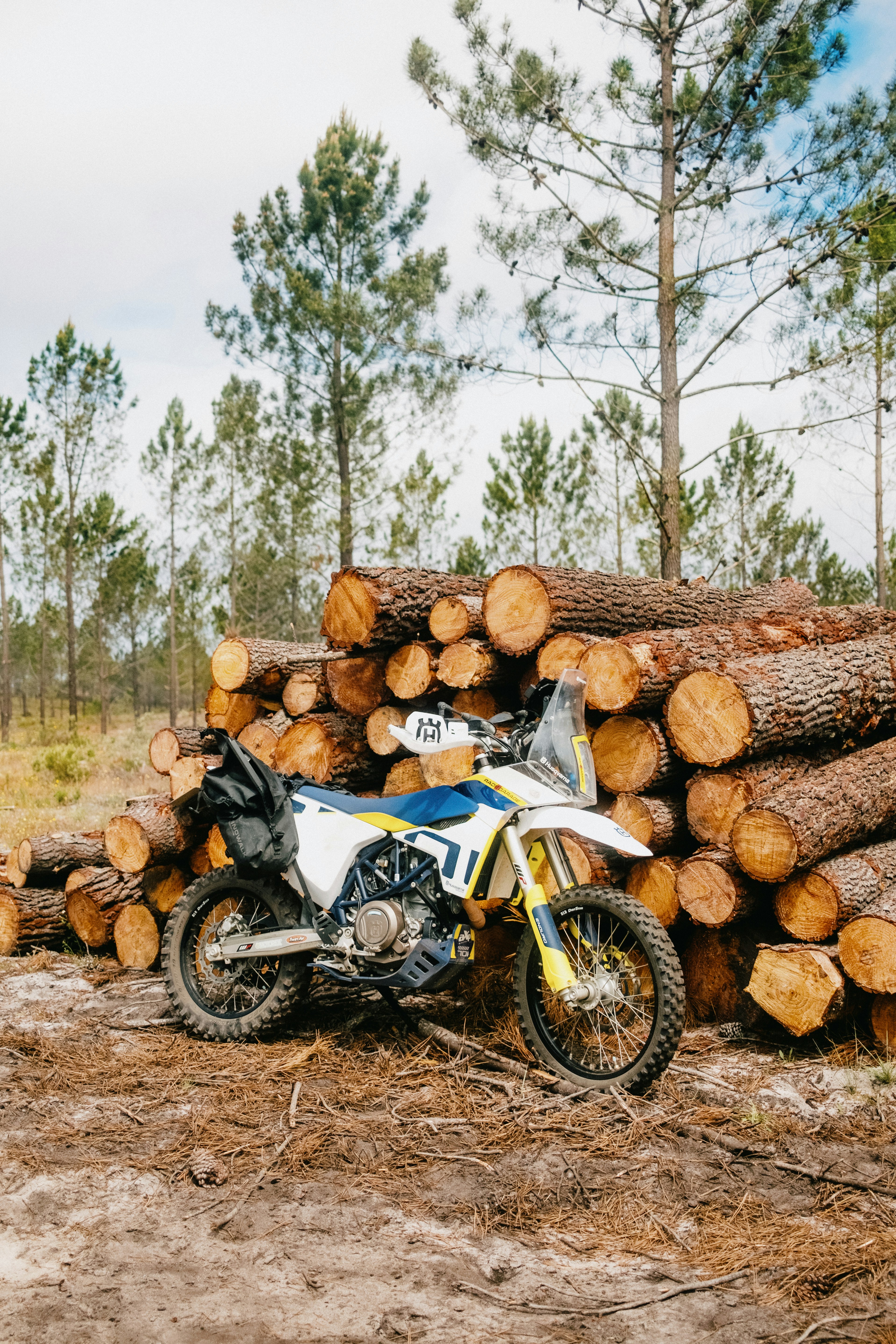 a motorcycle parked next to a pile of logs