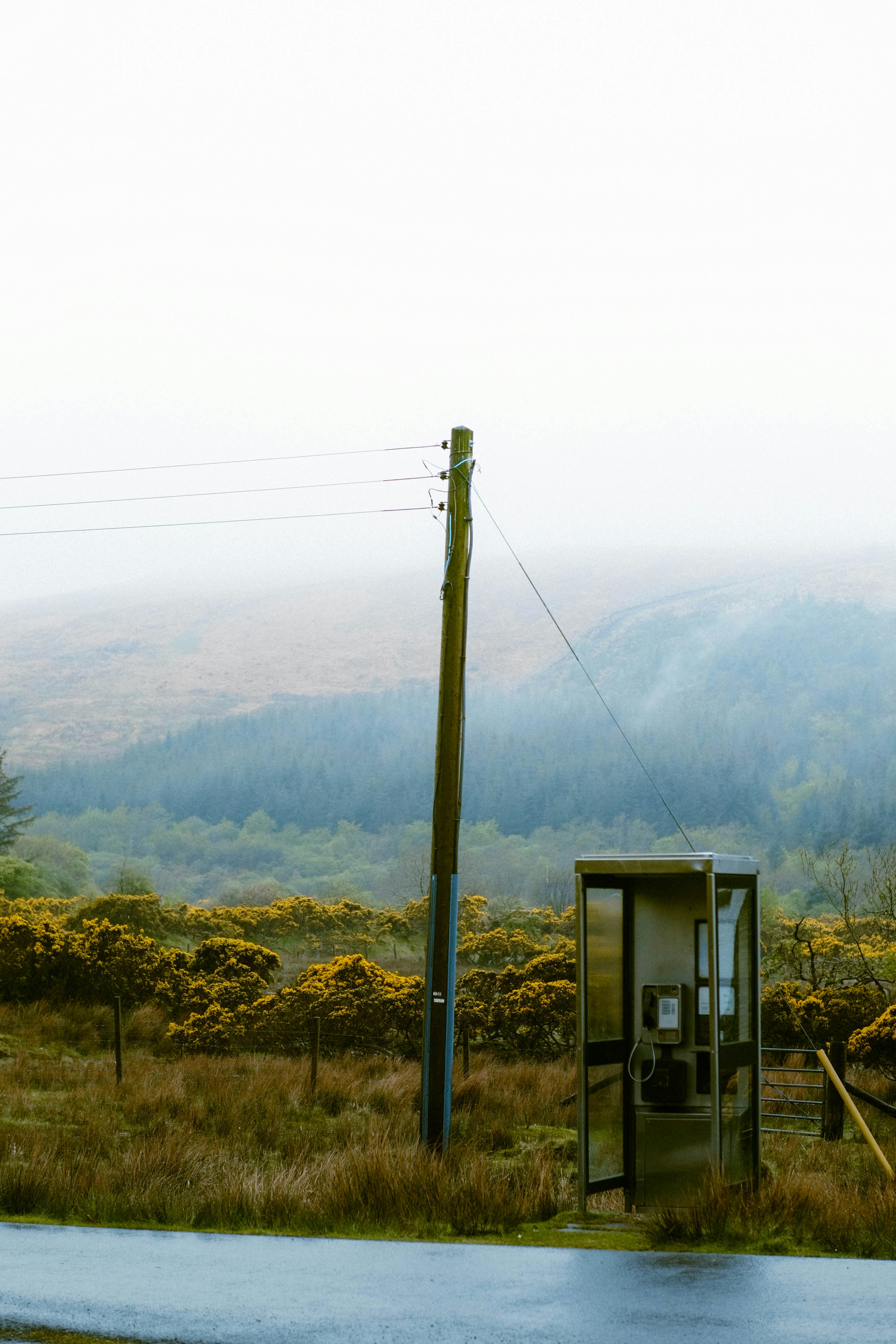 a telephone booth sitting on the side of a road