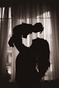 a silhouette of a woman holding a baby in her arms