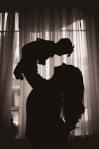 a silhouette of a woman holding a baby in her arms