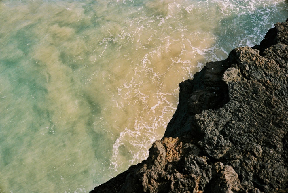 Eine Person, die auf einer Klippe neben dem Meer steht