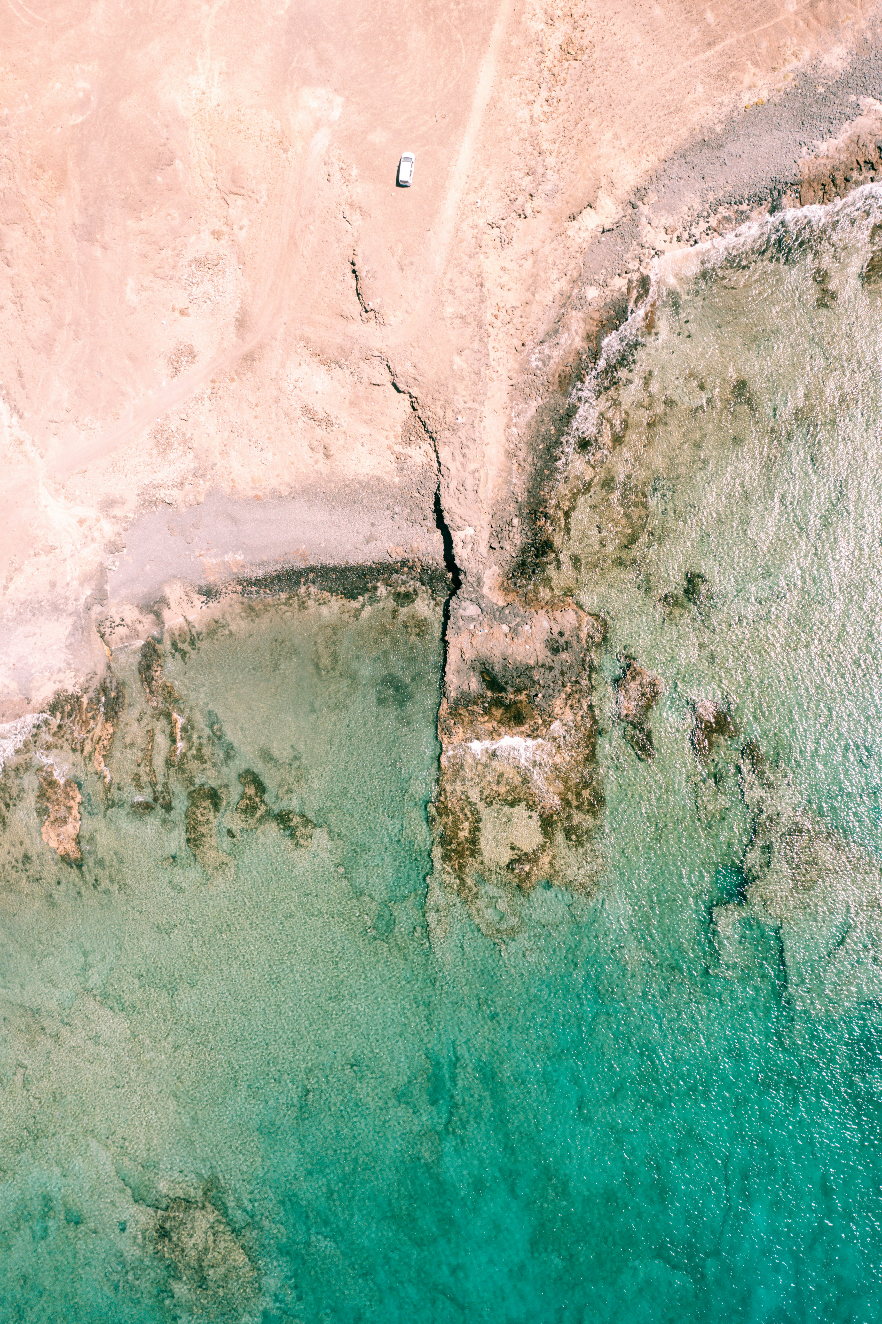 an aerial view of a beach with a boat in the water