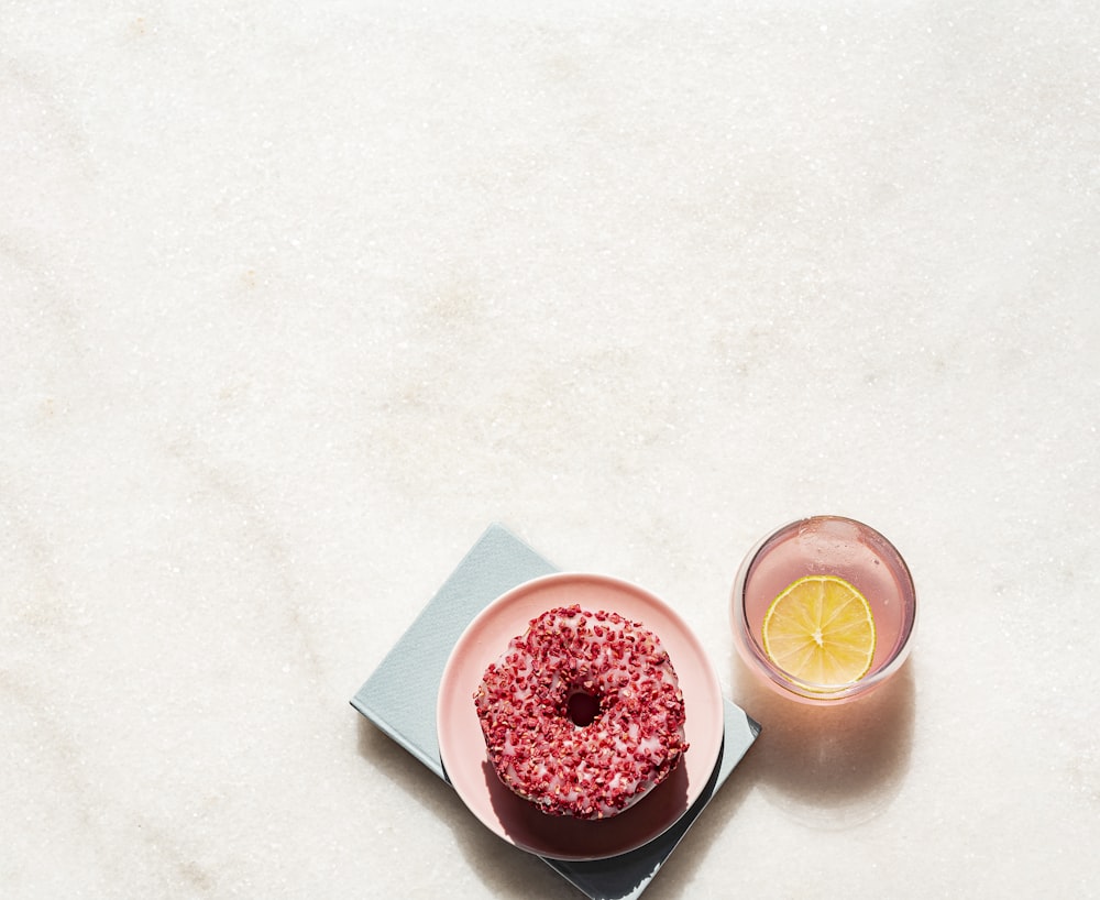 a plate with a donut on it next to a glass of water
