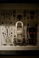 a display case with a white car surrounded by assorted parts