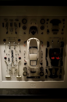 a display case with a white car surrounded by assorted parts