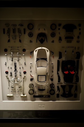 a display case with a white car surrounded by assorted parts