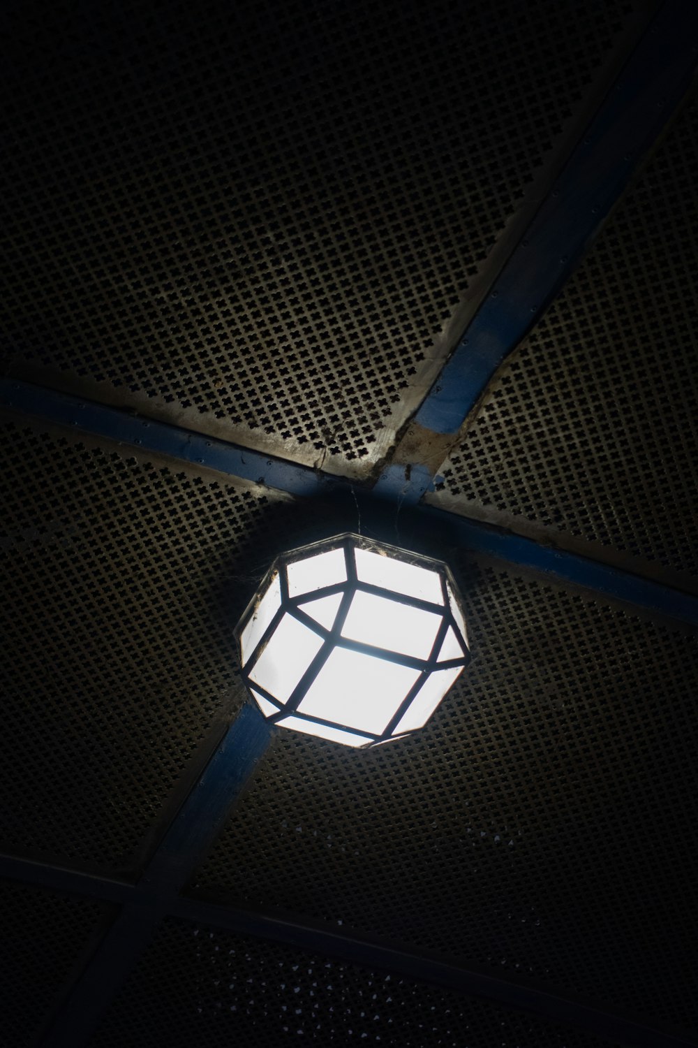 a white light hanging from the ceiling of a building