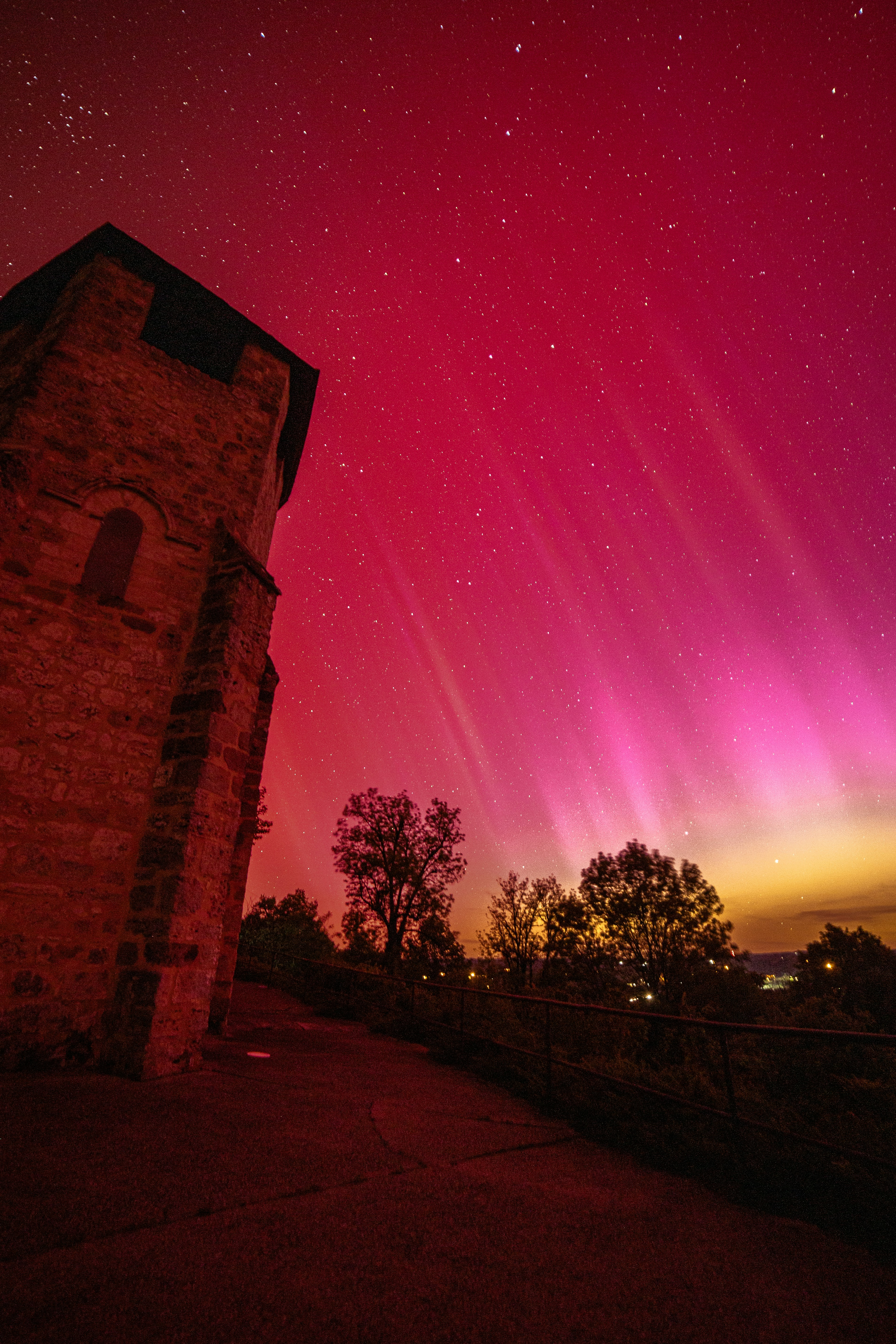 a red and purple aurora over a brick building