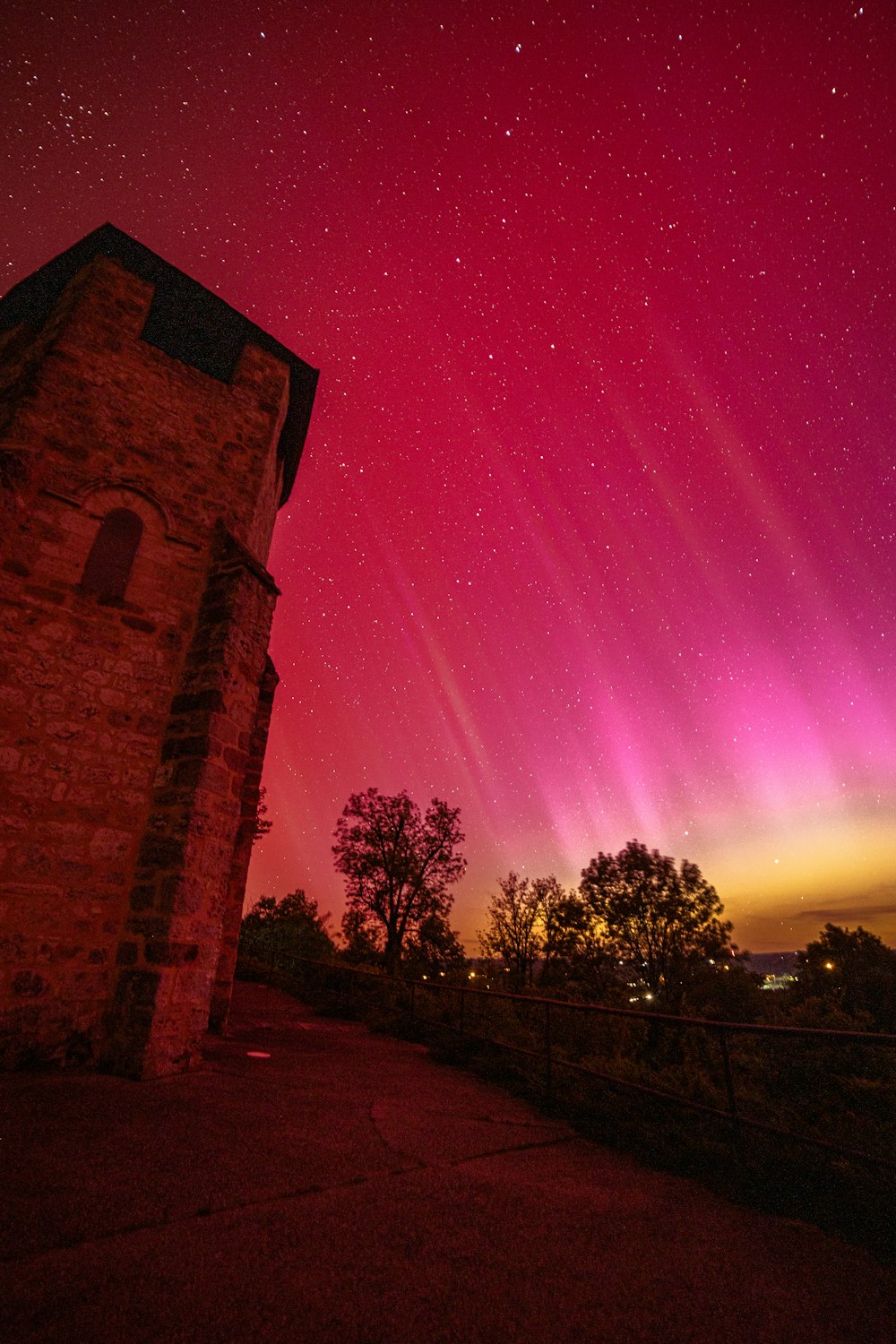 a red and purple aurora over a brick building