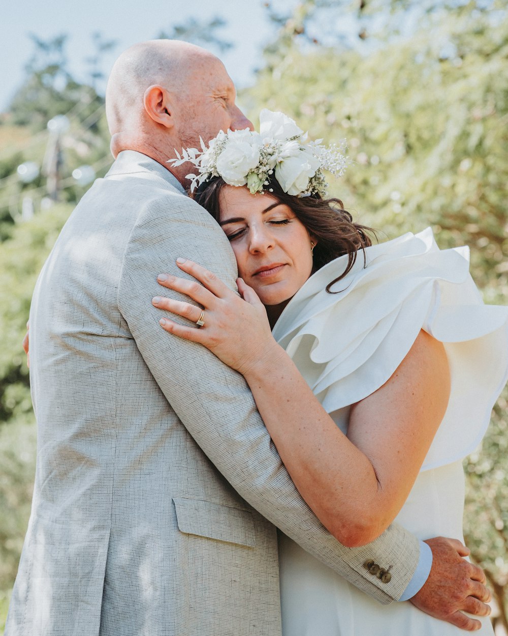 a bride and groom embracing each other outside