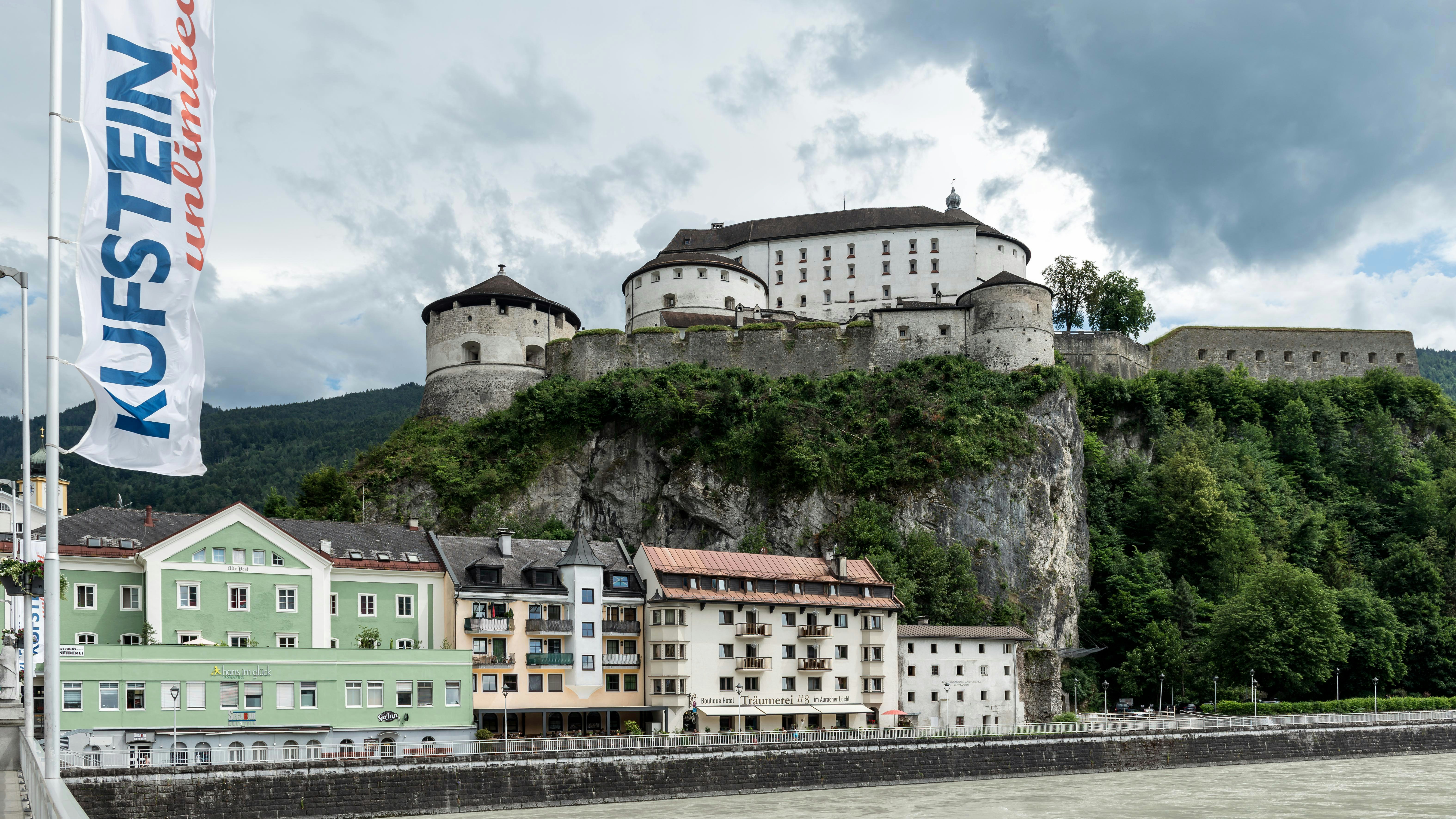 a castle on top of a hill next to a body of water