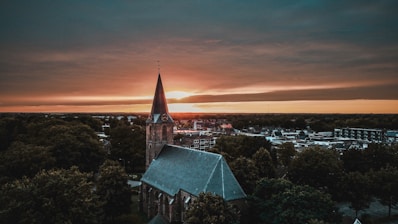 a church steeple with a sunset in the background