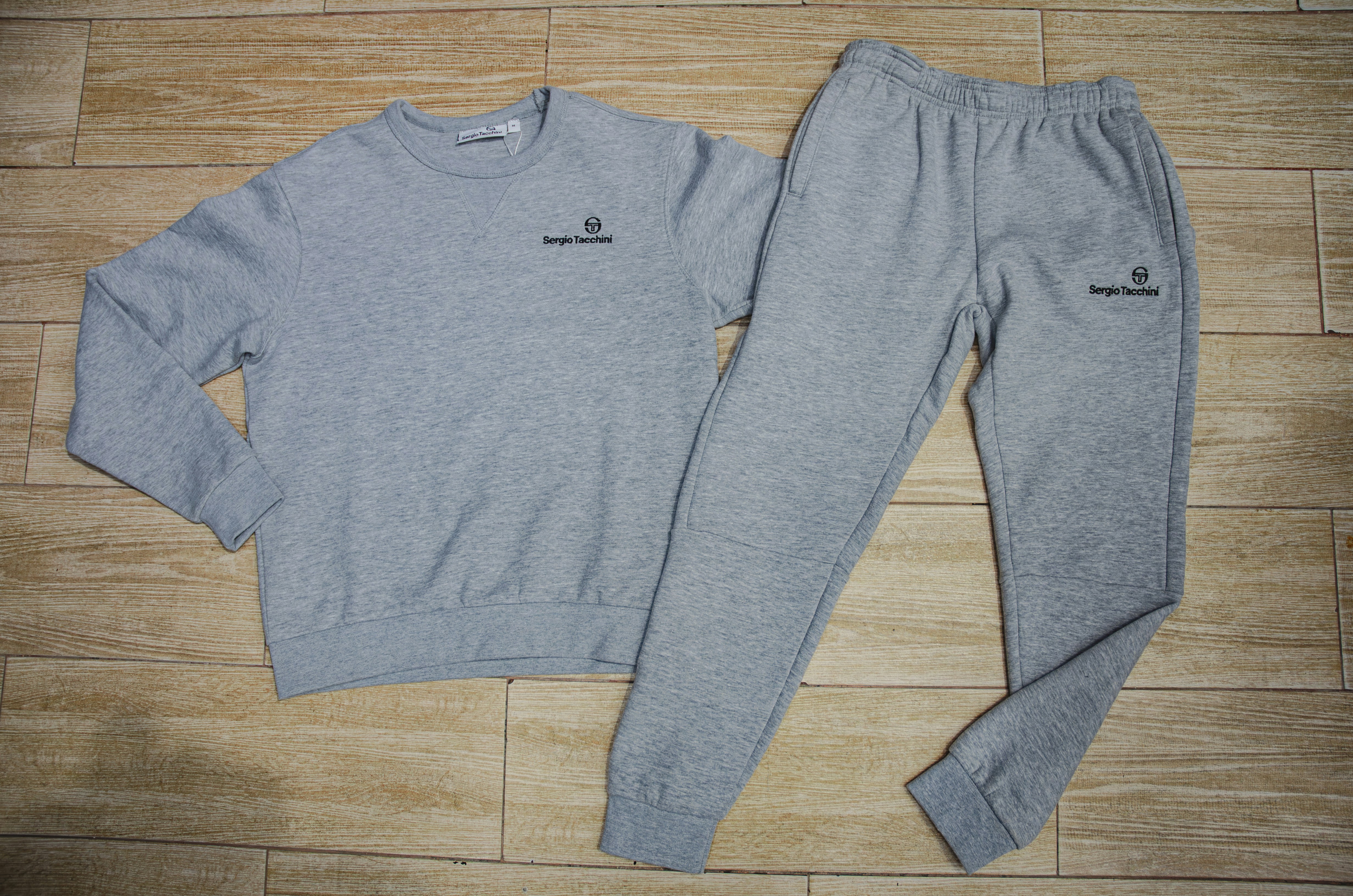a pair of sweatpants and a sweatshirt on a wooden floor