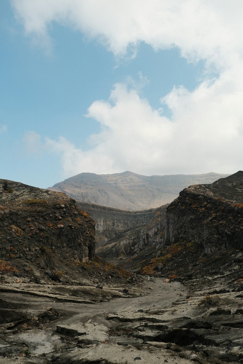 a dirt road with a mountain in the background