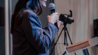 a woman standing at a podium holding a microphone