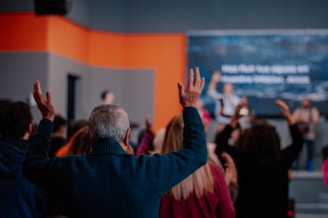 a group of people standing in a room with their hands up