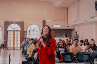 a woman standing in front of a crowd holding a microphone