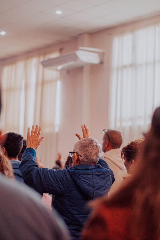 a group of people in a room with their hands up