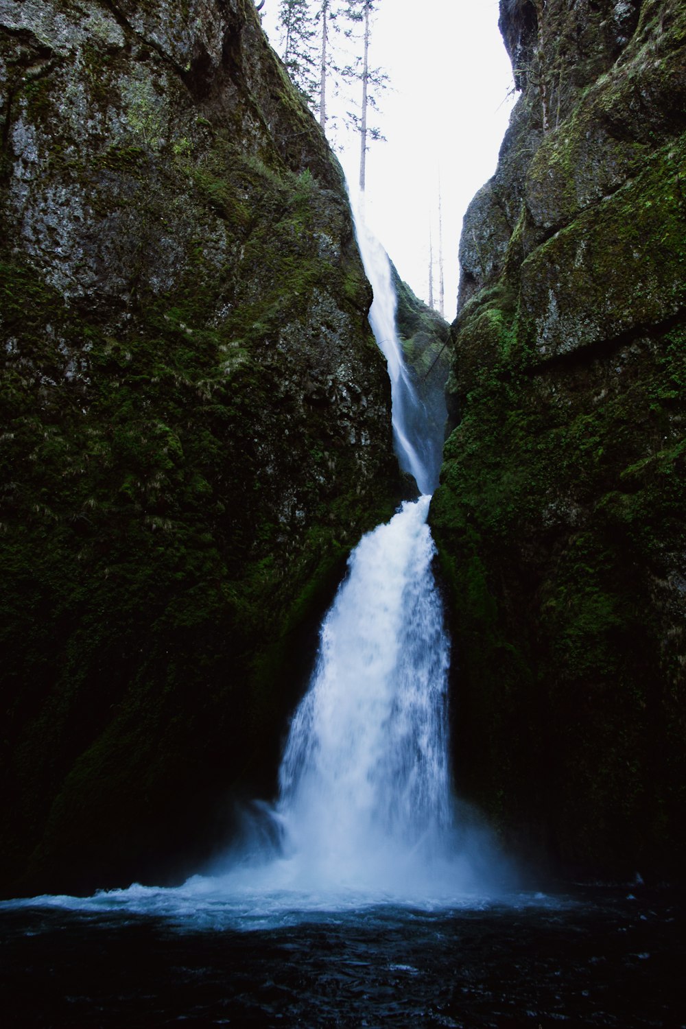 a large waterfall is coming out of the side of a cliff