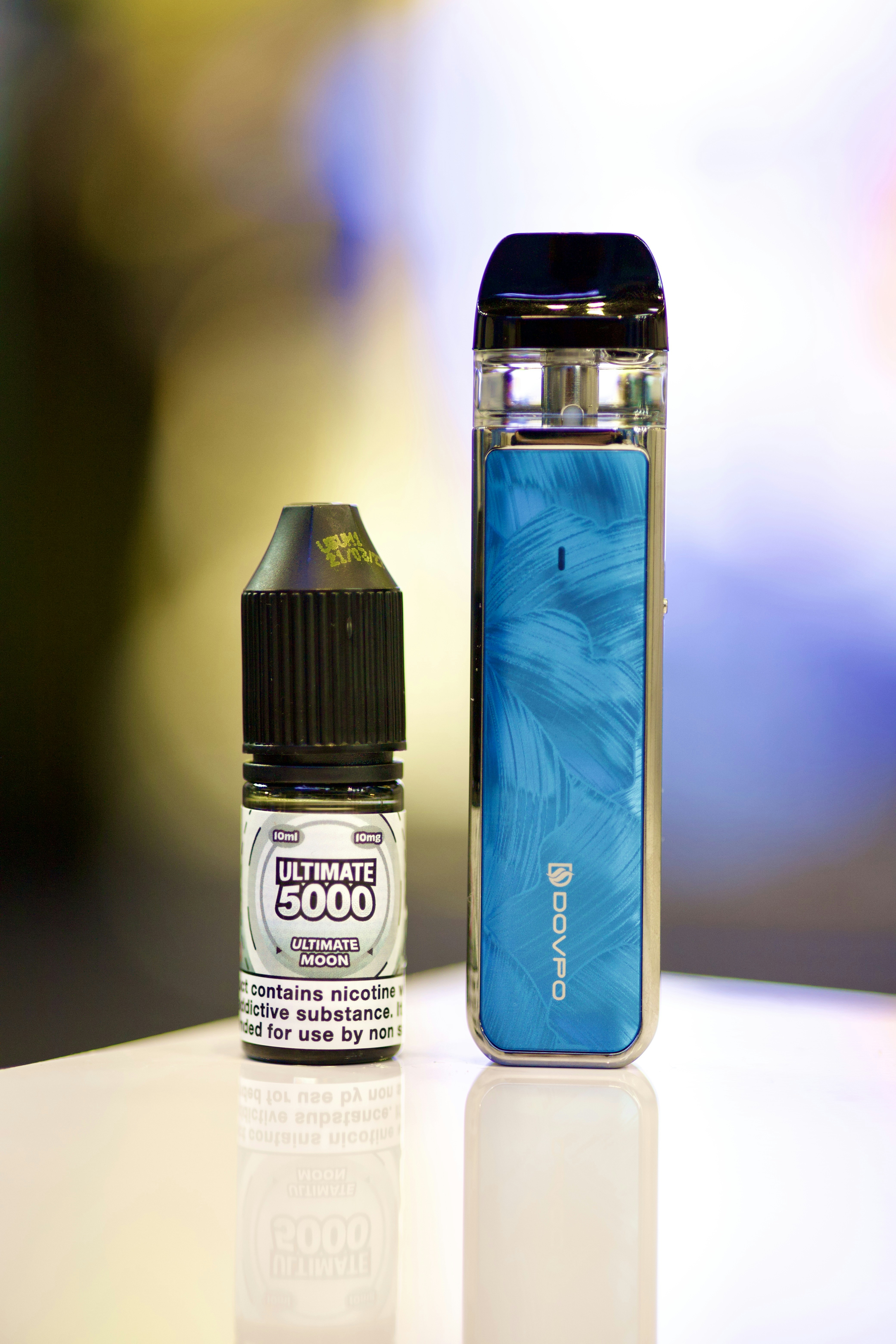 an electronic device next to a bottle of liquid