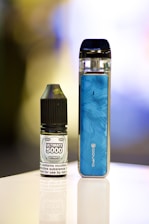 an electronic device next to a bottle of liquid