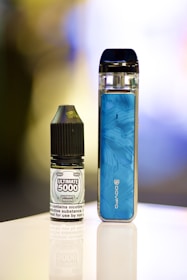 an electronic device next to a bottle of liquid