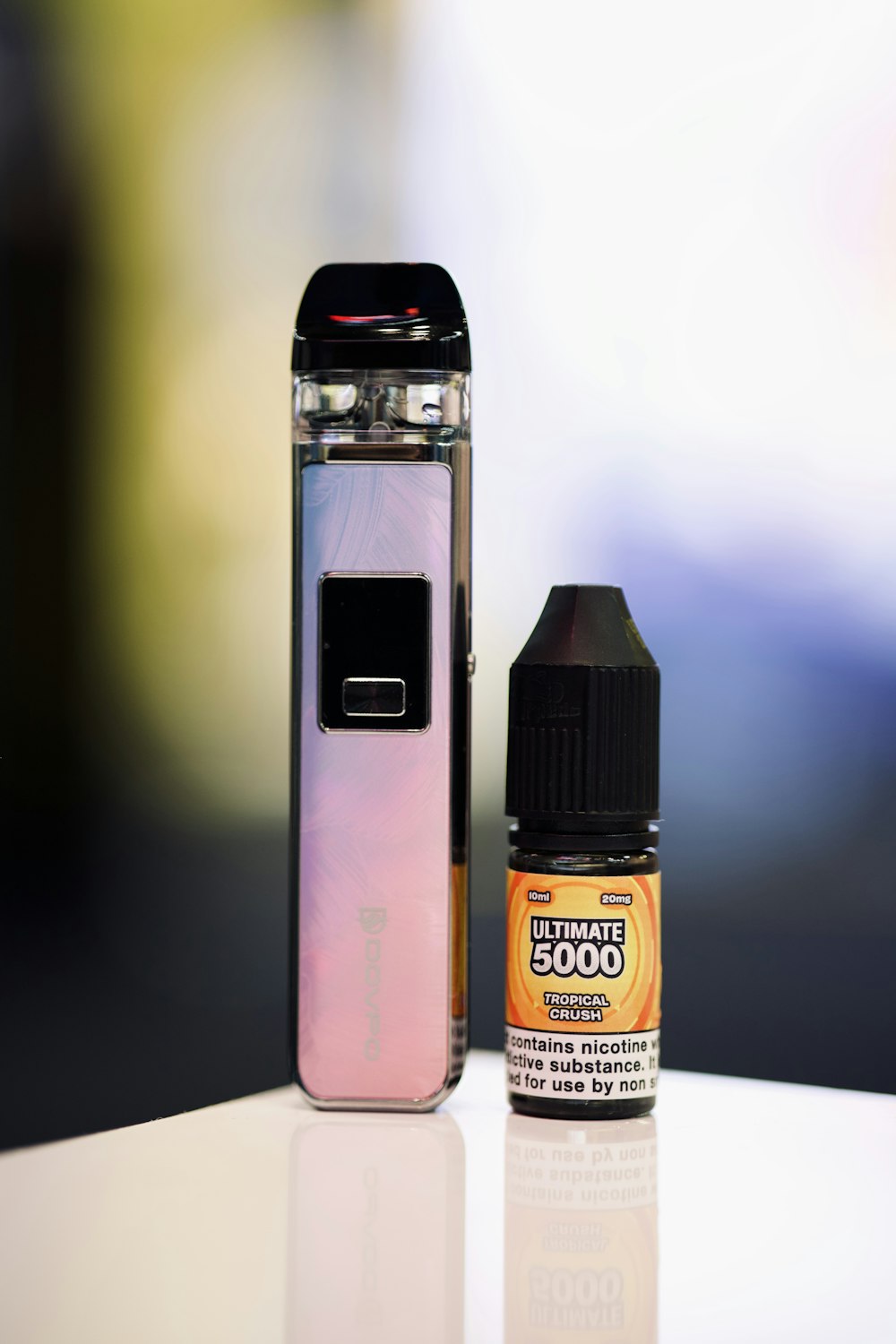 a bottle of e - liquid next to an electronic device