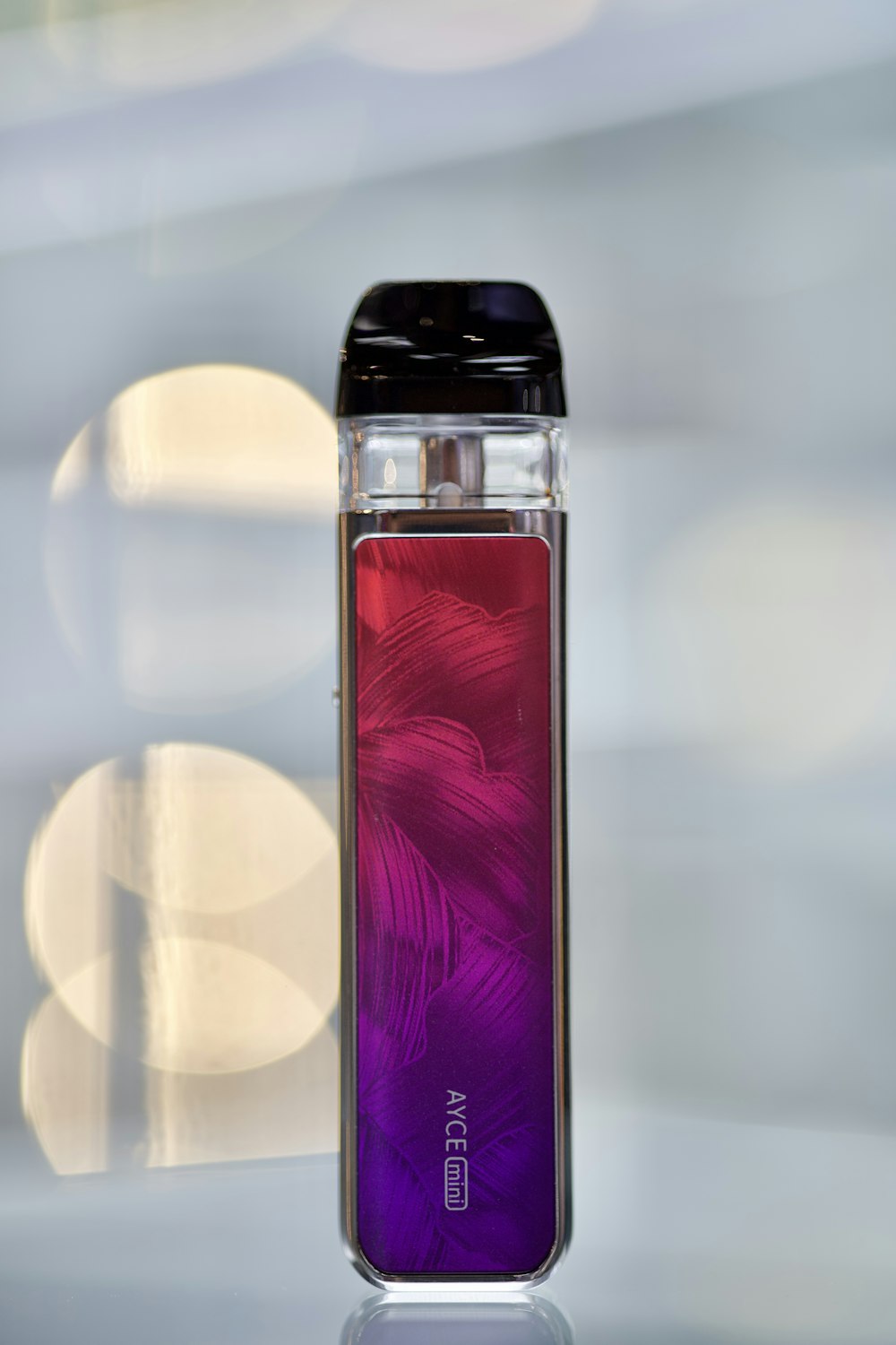 a glass bottle with a purple and red design on it