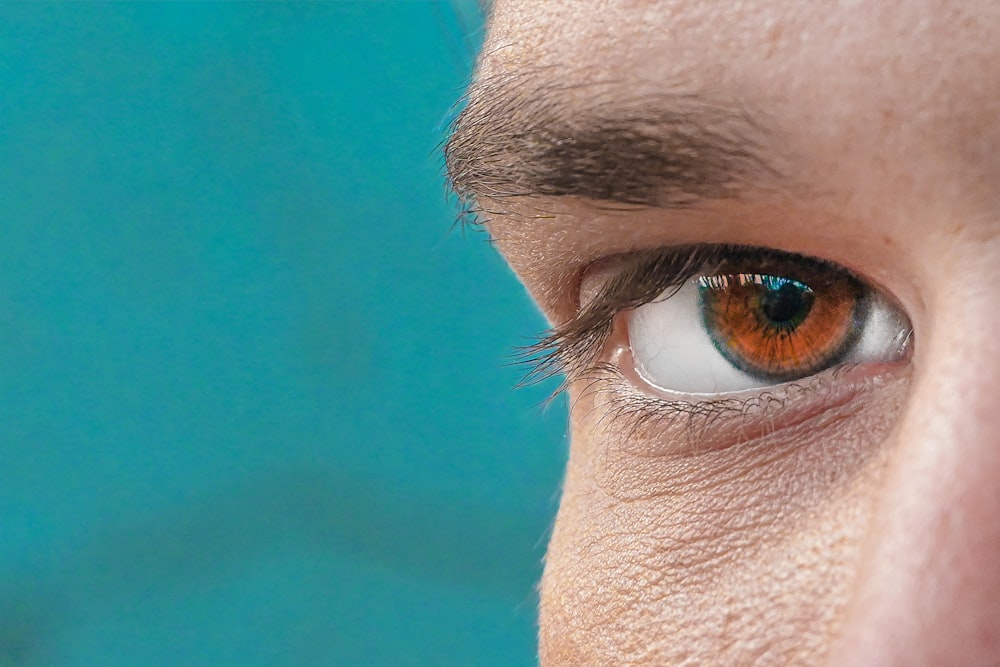 a close up of a person's eye with a blue background