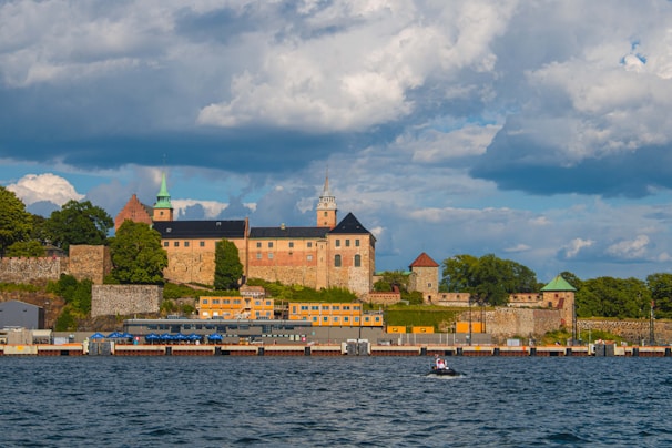 a large castle sitting on top of a hill next to a body of water