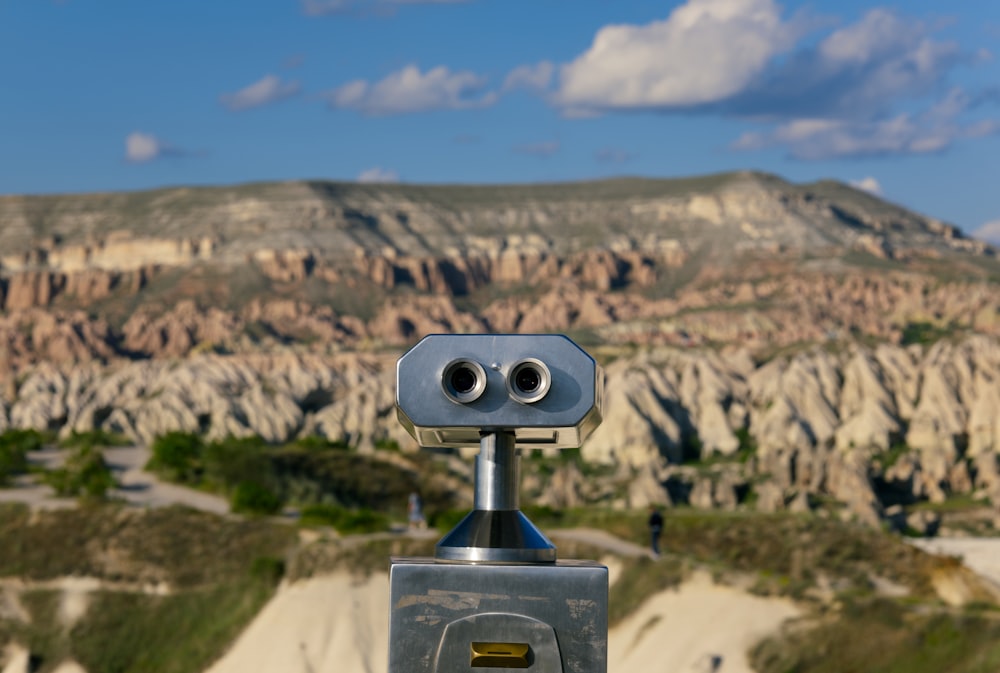 a close up of a camera with a mountain in the background