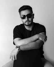 a man with his arms crossed sitting on a chair