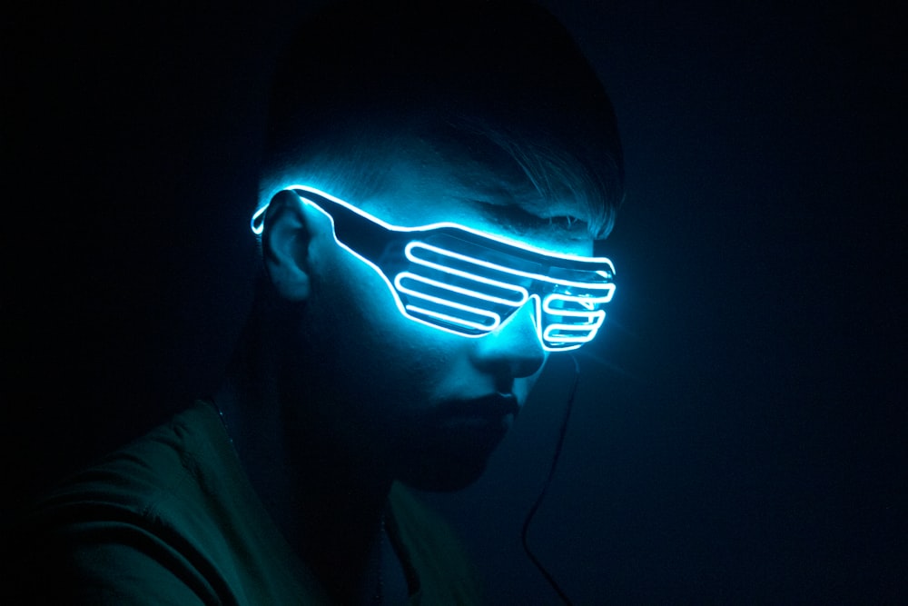 a man wearing a neon mask in the dark